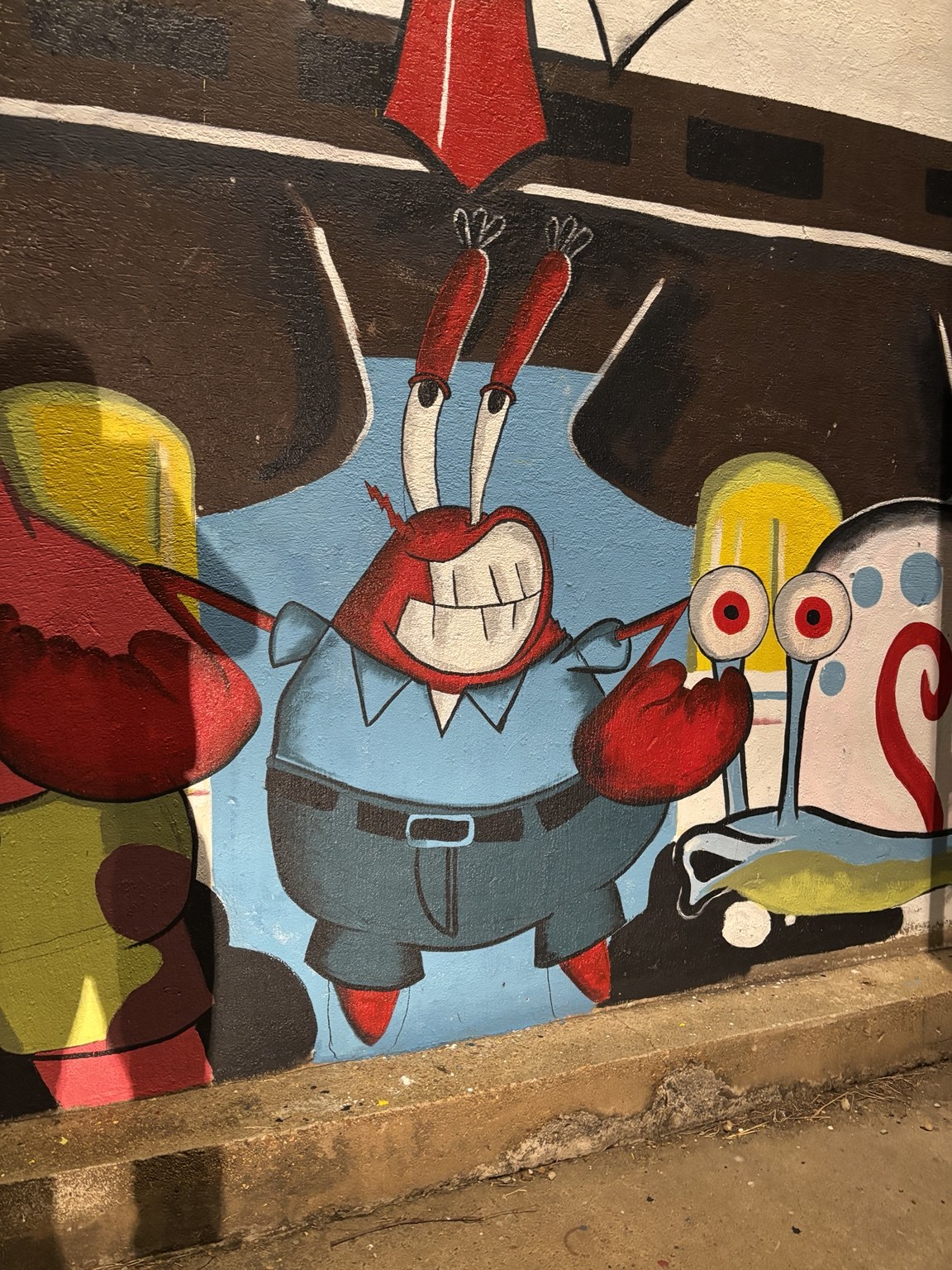 A close-up of the hand-painted Mr. Krabs and Gary mural at Carnival Treats